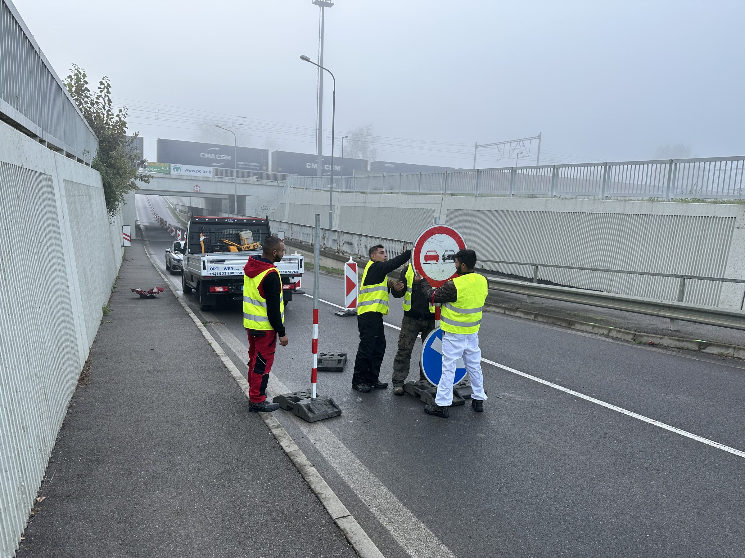 Robotníci v reflexných vestách pri uzávierke podjazdu